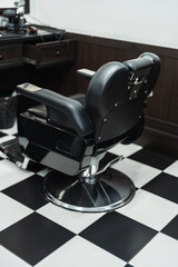 Classic barber chair set against a stylish black and white tiled floor