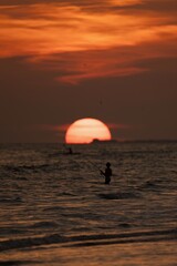 Fisherman Silhouetted Against Ocean Sunset with Fiery Sky