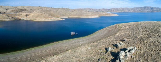 Aerial view of San Luis Reservoir, Santa Nella, California, USA, showing low water levels and...