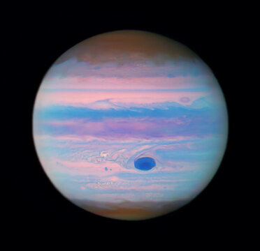 Infrared image of Jupiter showing vibrant bands and a dark storm. Image courtesy of NASA.