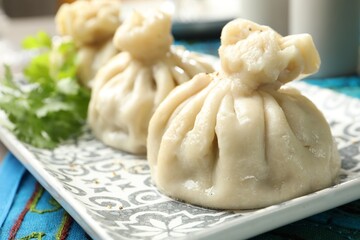 Delicious cooked khinkali served on table, closeup