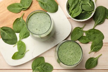 Tasty smoothie and spinach leaves on white wooden, flat lay