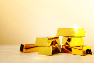 Shiny gold bars on beige background. Space for text