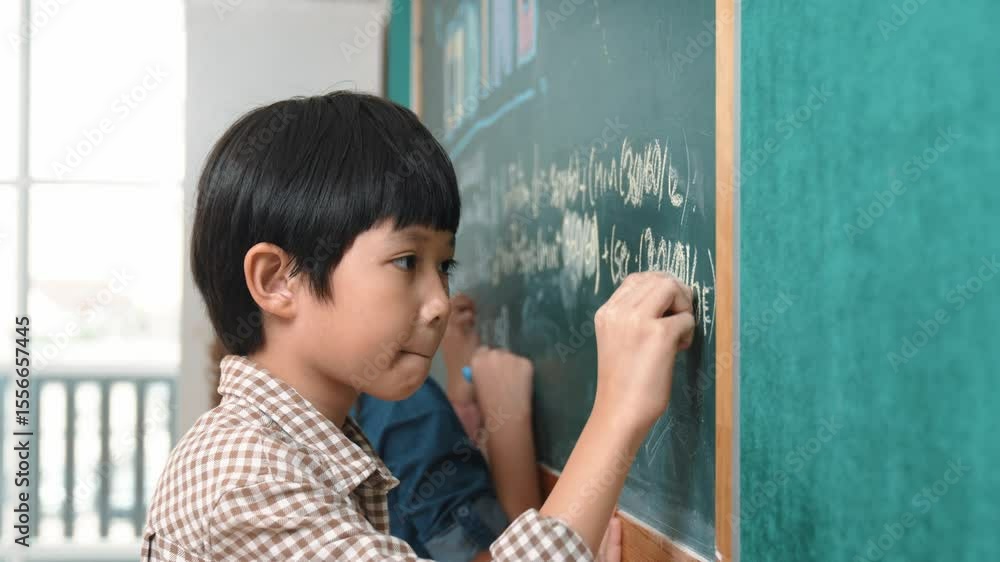 Poster side view of asian boy writing engineering prompt and programing system while standing blackboard wi