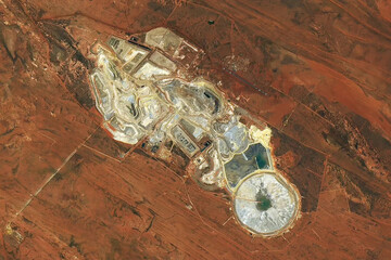 A satellite view of the Telfer gold and copper mine in Western Australia, showing terraced open-pit operations and tailings ponds. Image courtesy of NASA. © Bluee