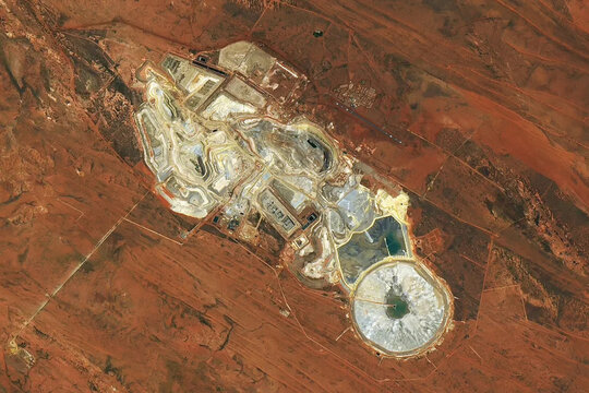 A satellite view of the Telfer gold and copper mine in Western Australia, showing terraced open-pit operations and tailings ponds. Image courtesy of NASA.