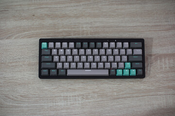 Teal And Gray Compact Keyboard On Light Wood Desk