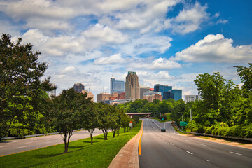 A highway skyline leading into the capital city Raleigh North Carolina on a nice cloudy day in summer.