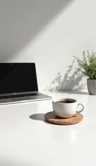 Obraz premium Coffee cup and laptop on table in office workspace