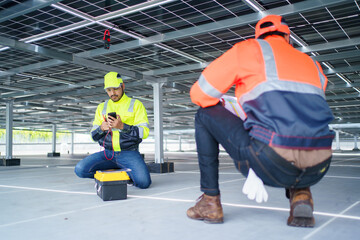 Electrical engineers are inspecting and installing a solar panels on the building rooftop.