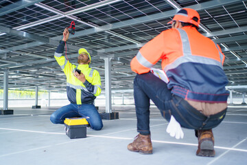 Electrical engineers are inspecting and installing a solar panels on the building rooftop.