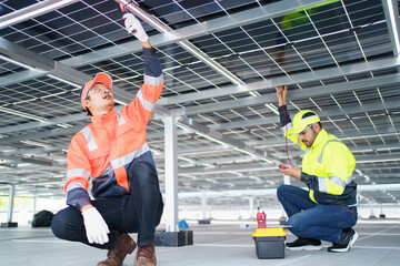 Electrical engineers are inspecting and installing a solar panels on the building rooftop.