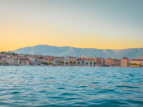 Sunset over Split, Croatia, with historic waterfront buildings and distant mountains reflected in the Adriatic Sea&mdash;an idyllic Mediterranean cityscape full of charm and color.