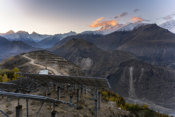 A breathtaking view of snow-covered mountain peaks illuminated by golden sunlight at sunset....