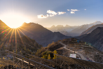 Sunrise over a mountainous landscape with solar panels in the foreground, highlighting the blend of...