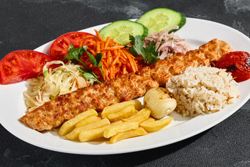 Chicken lula kebab with vegetables and pilaf, bright overhead, dynamic white plate composition