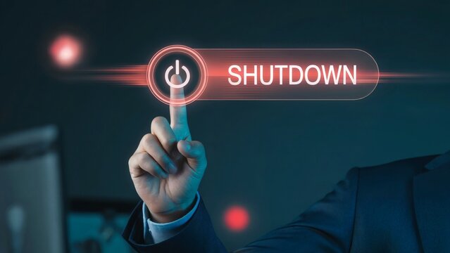 Hand triggers glowing red shutdown symbol in digital interface, surrounded by neon orbs in dark futuristic atmosphere