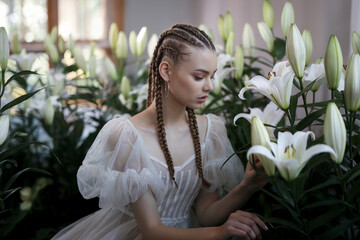 A soft, ethereal portrait photograph of a young woman in a white Victorian-style dress with sheer puff sleeves and a pleated bodice. 