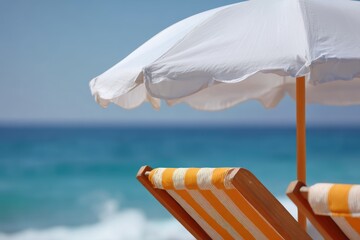 Beach umbrella and lounge chair facing ocean view