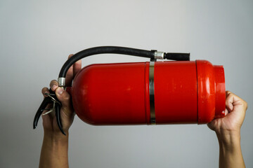 Hands Holding a Red Fire Extinguisher, a person's hands gripping a portable red fire extinguisher.