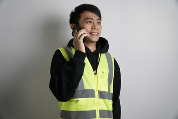 Young Asian Man in Safety Vest on Phone