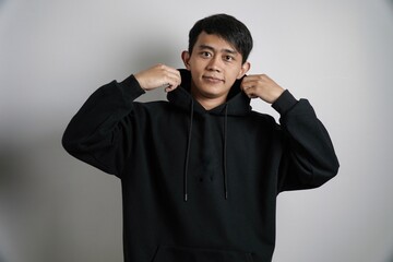 Smiling Asian Man Adjusting Hoodie