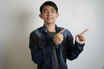 Smiling Young Asian Man Pointing Both Sides