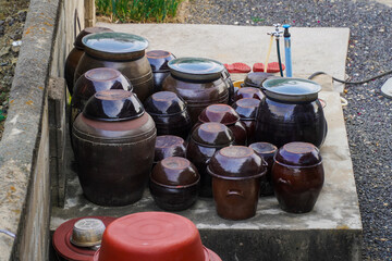 Assorted traditional Korean jangdok pottery jars used for fermenting sauces and kimchi, showcasing...