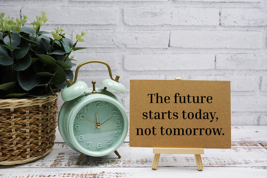 The future starts to day, not tomorrow text message with easel stand on wooden background