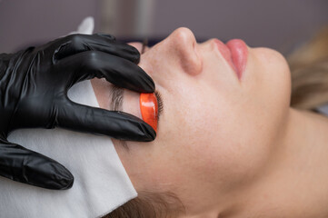 Caucasian woman undergoing eyelash lamination procedure. 