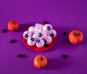Pumpkins, little black spiders and eye-shaped cakes ready for a creepy and scary Halloween party