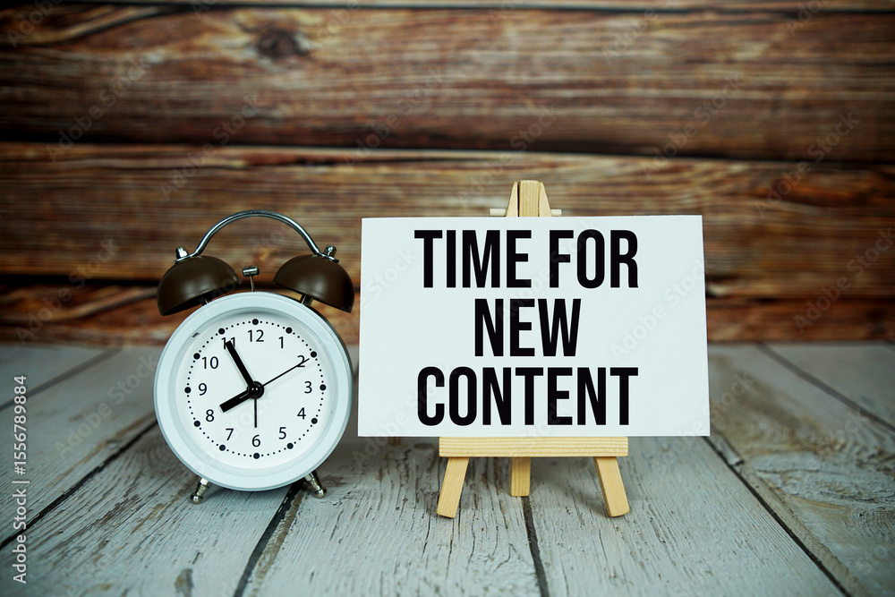 Poster time for new content text with easel and alarm clock on wooden background