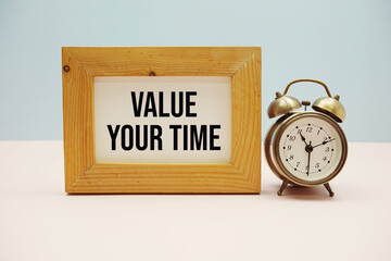 Value Your Time text with alarm clock on blue and pink background