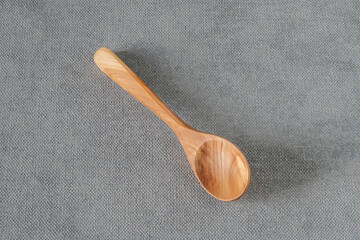Wooden spoon on grey tablecloth.