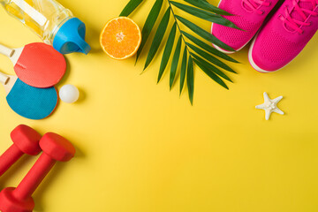 Summer fitness background with dumbbells, bottle of water, ping pong rackets; sport shoes and palm...