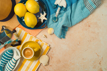 Mediterranean summer vacation concept with straw hat, lemons and coffee cup on striped towel...