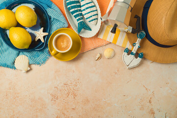 Mediterranean summer vacation concept with straw hat, lemons and coffee cup on striped towel...