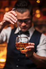 Bartender is pouring whiskey into a glass a customer's glass.
