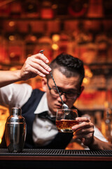 Bartender is pouring whiskey into a glass a customer's glass.	

