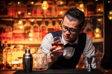 Bartender is pouring whiskey into a glass a customer's glass.