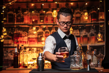 Bartender is pouring whiskey into a glass a customer's glass.	
