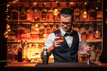 Bartender is pouring whiskey into a glass a customer's glass.	
