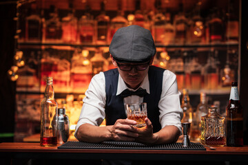 Bartender is pouring whiskey into a glass a customer's glass.	