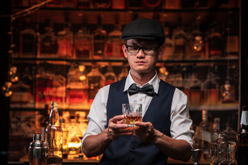 Bartender is pouring whiskey into a glass a customer's glass.