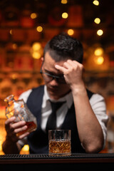 Bartender is pouring whiskey into a glass a customer's glass.