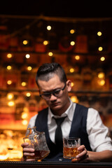 Bartender is pouring whiskey into a glass a customer's glass.	
