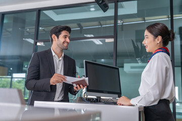 smiling businessman in suit standing at counter,waiting attendant,screening boarding pass at gates before entrance to airplane,travel,business,airlines