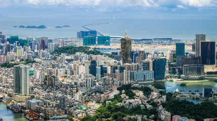 Aerial view of the dense Macau cityscape featuring modern skyscrapers and a famous sea-crossing...