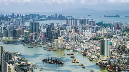 Aerial view of the dense urban cityscape and inner harbor with numerous transport boats under a...