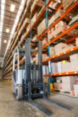 Forklift by rack in warehouse